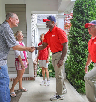 Wheaton employee shakes hands with older adult customer.