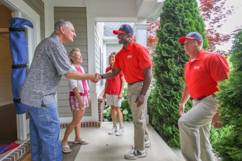 Wheaton employee shakes hands with older adult customer.