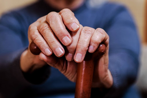 Hands holding a cane.