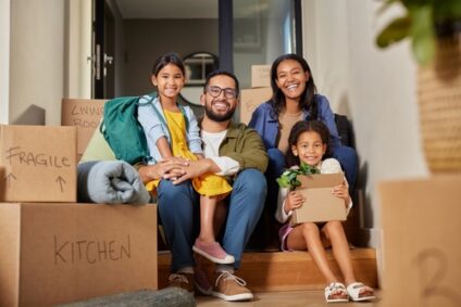 A family smiles among moving boxes