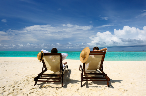 Two beach chairs face the ocean.